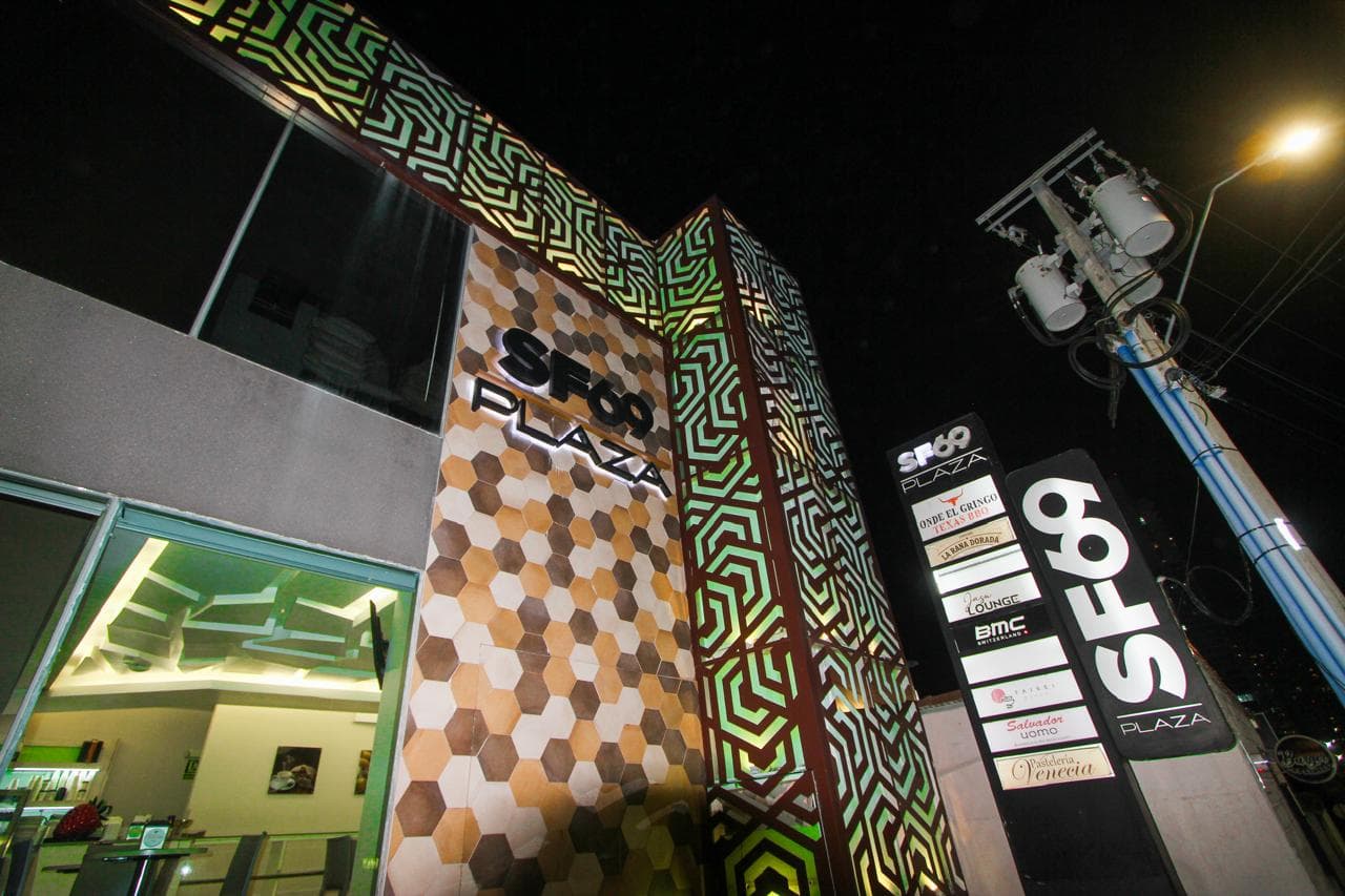 Hexagon-tiled corner and illuminated SF69 Plaza sign at night, San Francisco, Panama City