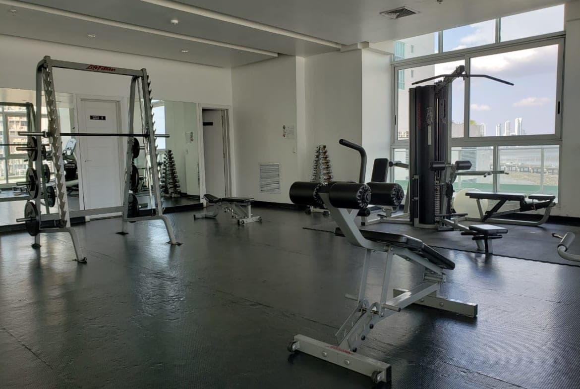Gym with weight machines and city views at PH Le Mare, Coco del Mar, Panama City