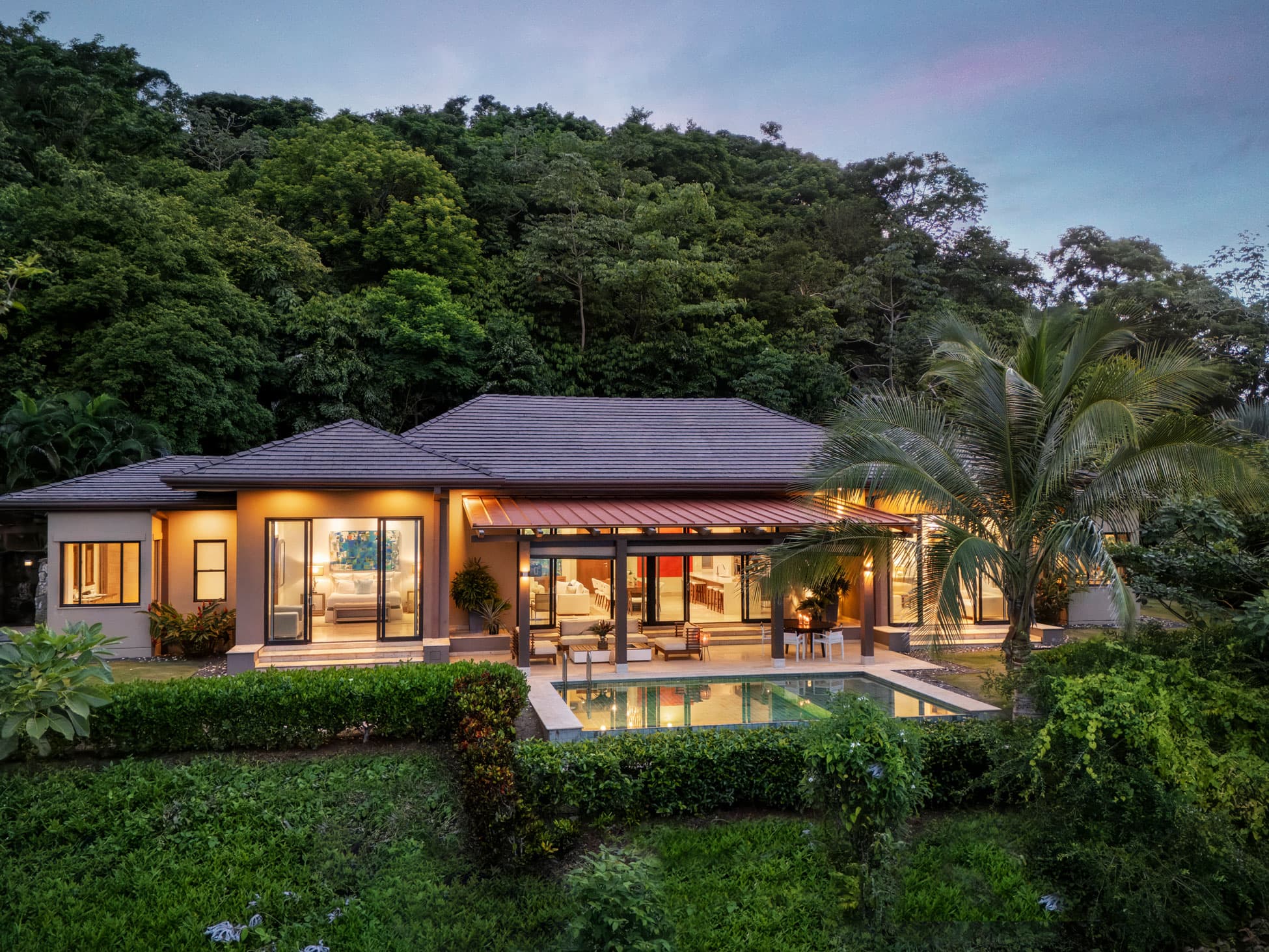 La Peninsula Villa at dusk with glowing interiors and private pool on Pearl Island