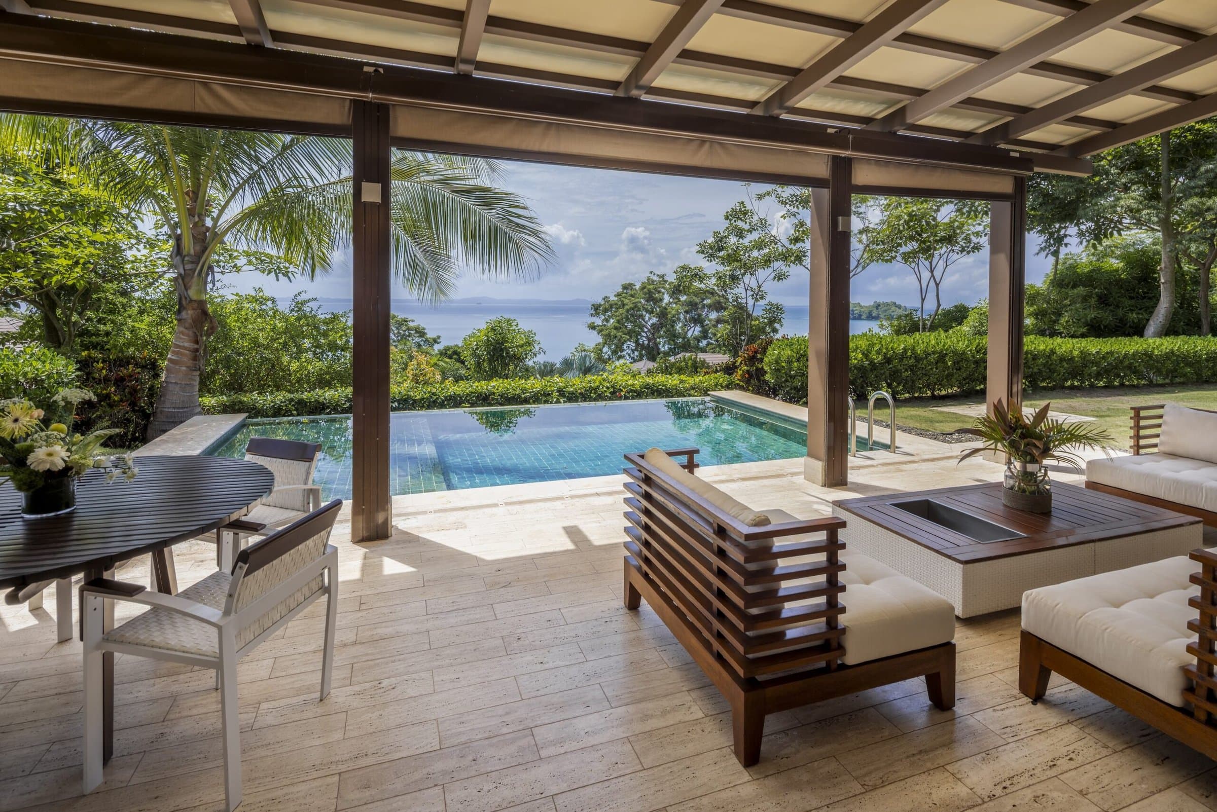 Covered terrace overlooking the infinity pool and ocean at a La Peninsula Villa