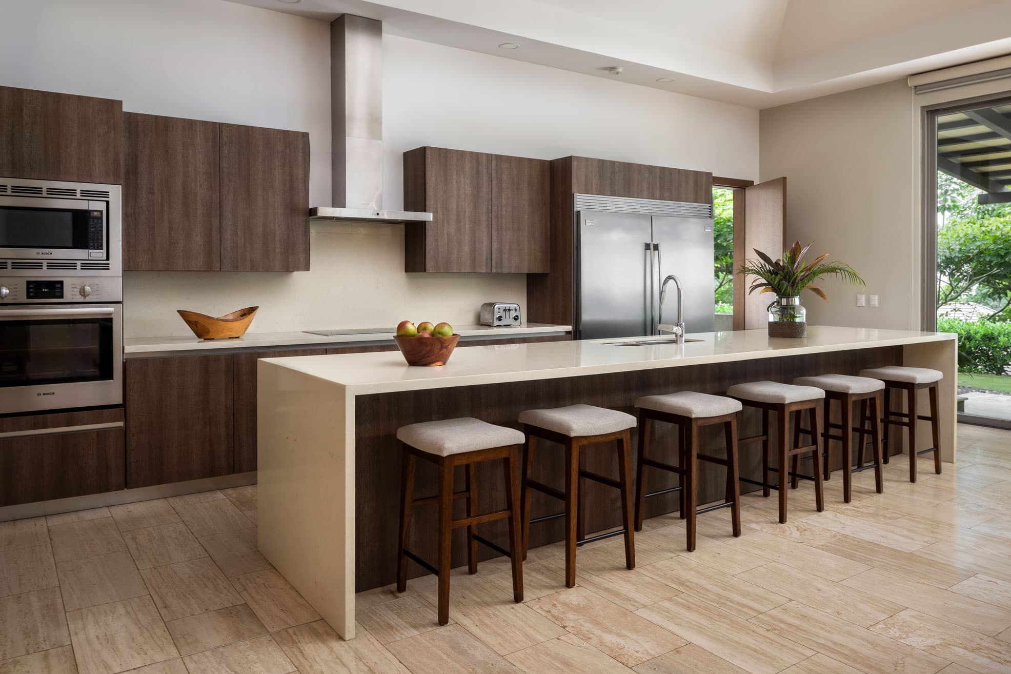 Chef's kitchen with island and bar seating in a La Peninsula Villa
