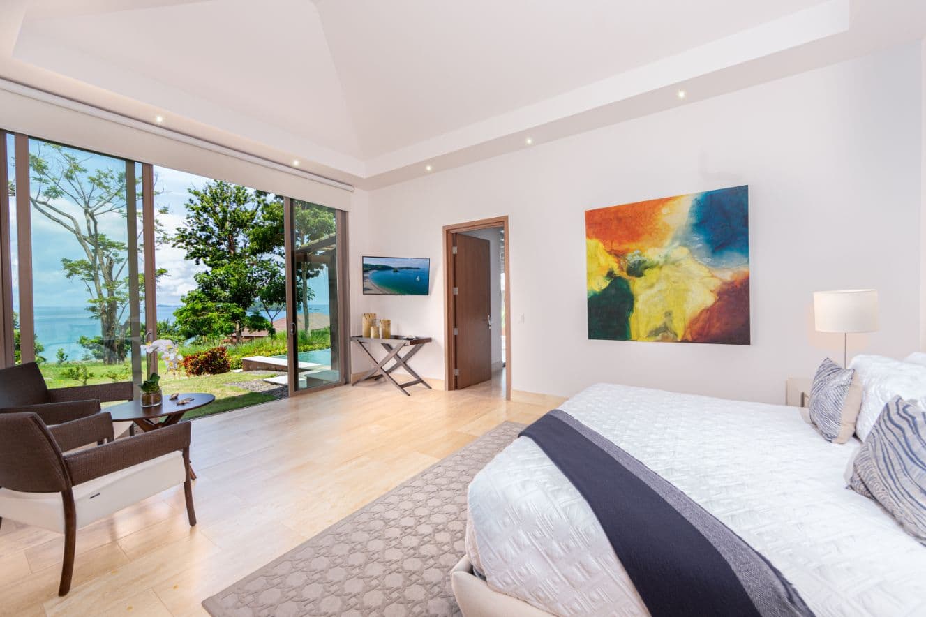 Primary bedroom with vaulted ceiling and ocean view in a La Peninsula Villa