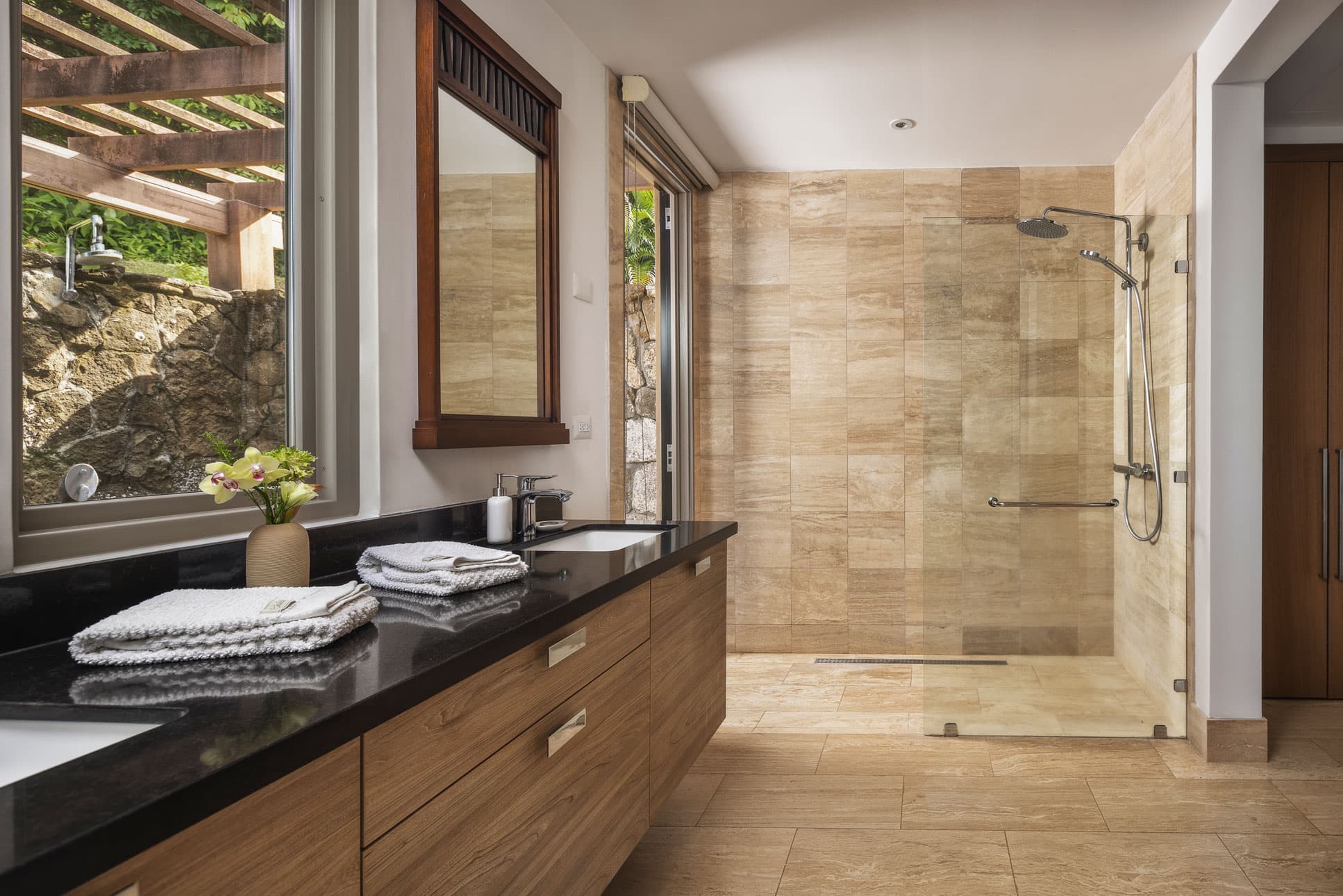 Stone-clad bathroom with walk-in shower in a La Peninsula Villa