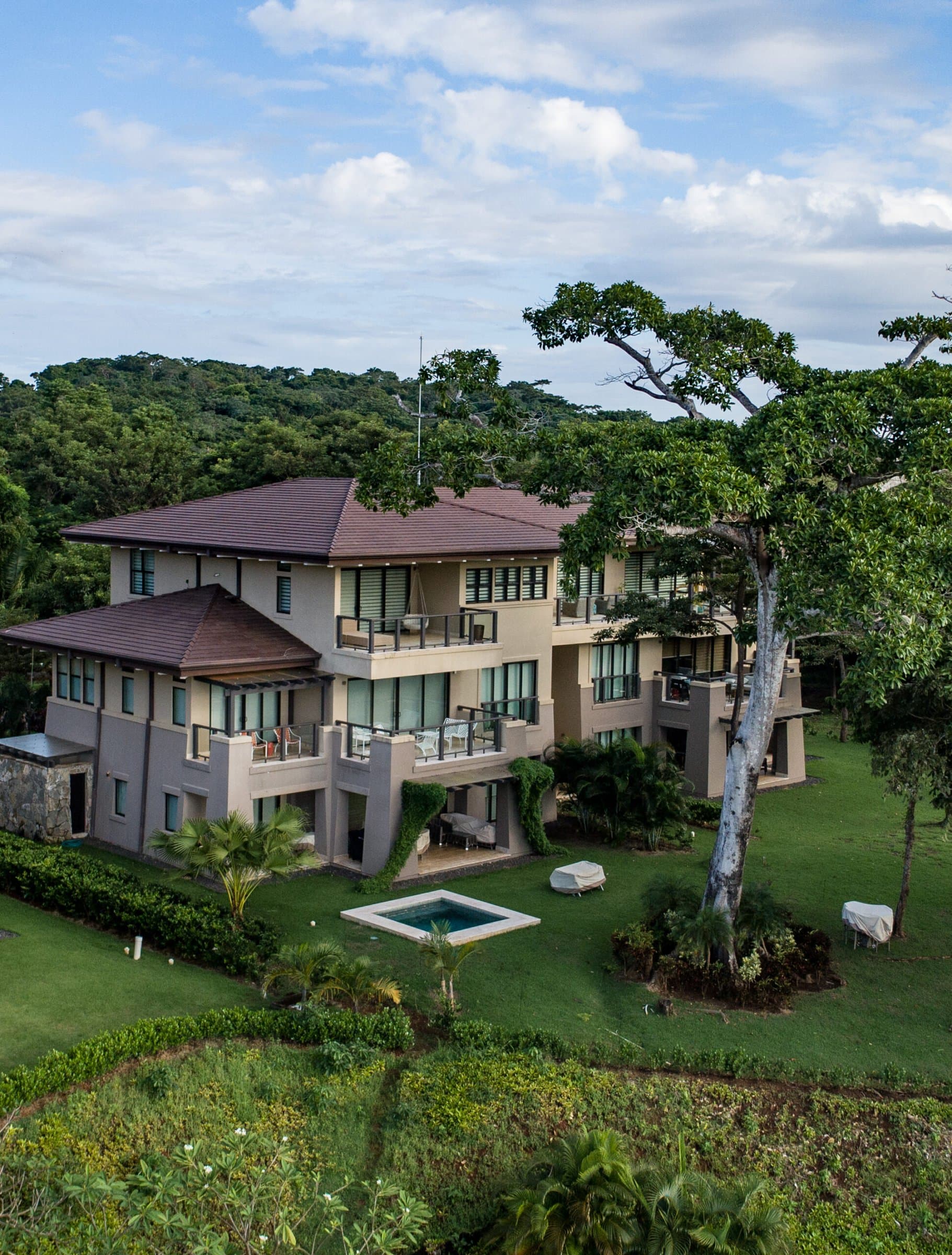 La Peninsula Club Residences building on its lawn above the sea at Pearl Island