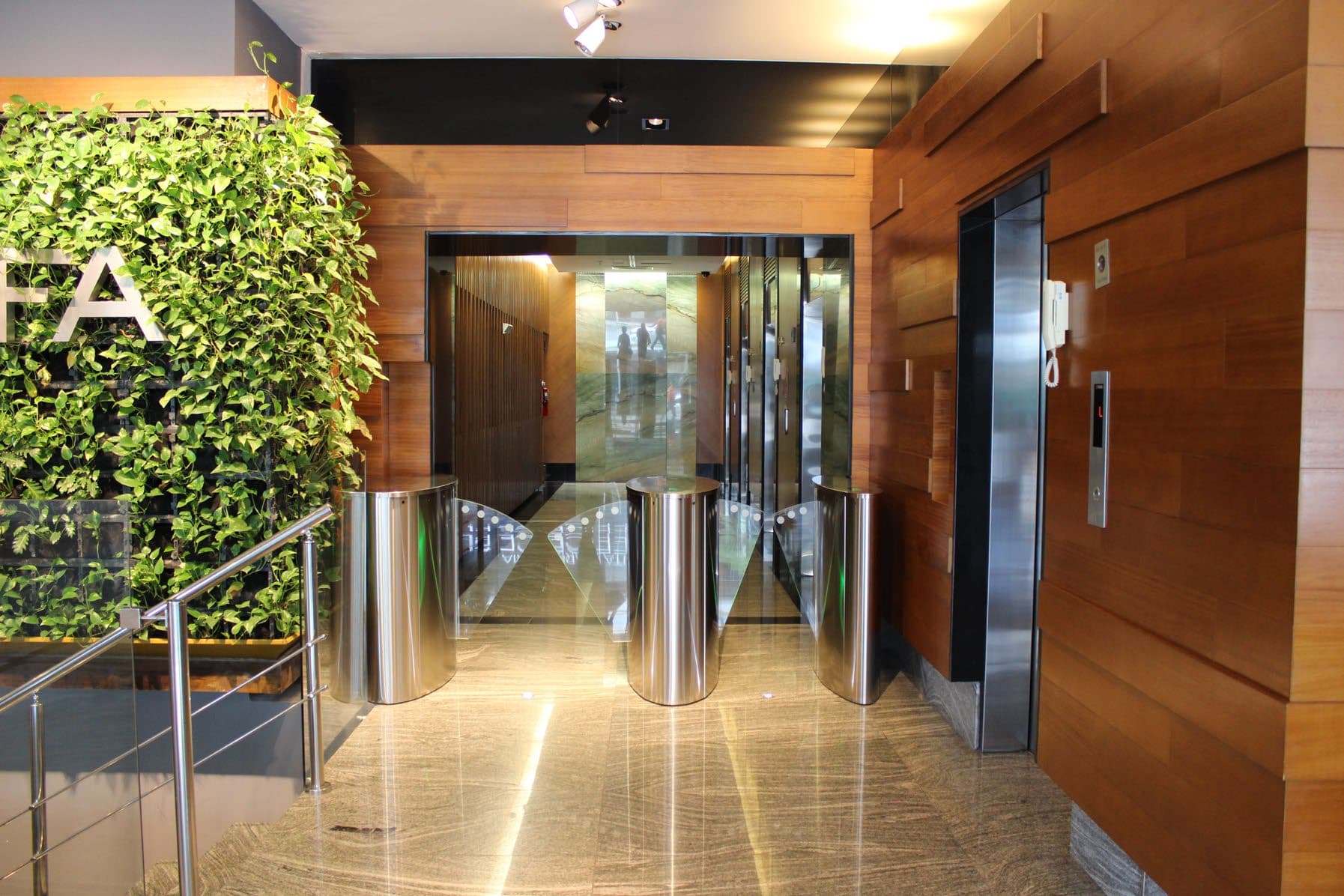 Access gates and elevator lobby at PH Arifa with wood-paneled walls