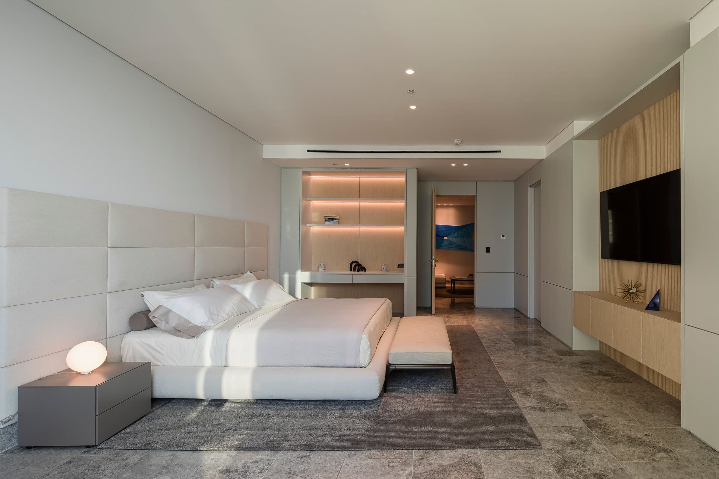 Primary bedroom with upholstered headboard in a Pacific Point Torre 400 residence