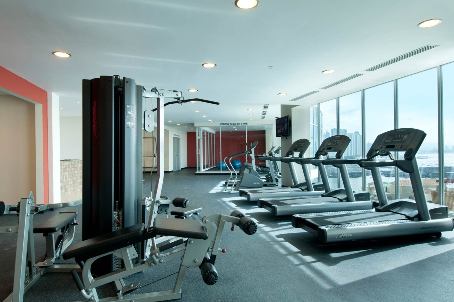Fitness center with treadmills and city views at Pacific Village