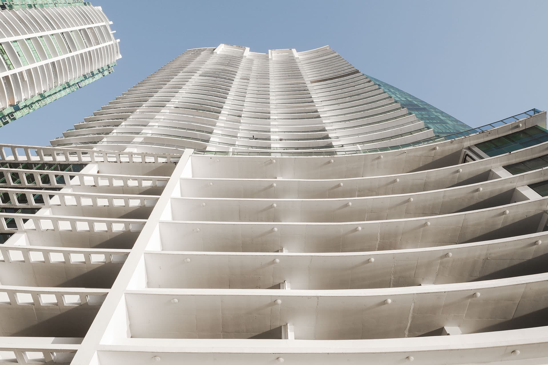 Upward view of the stacked white balconies of Grand Tower