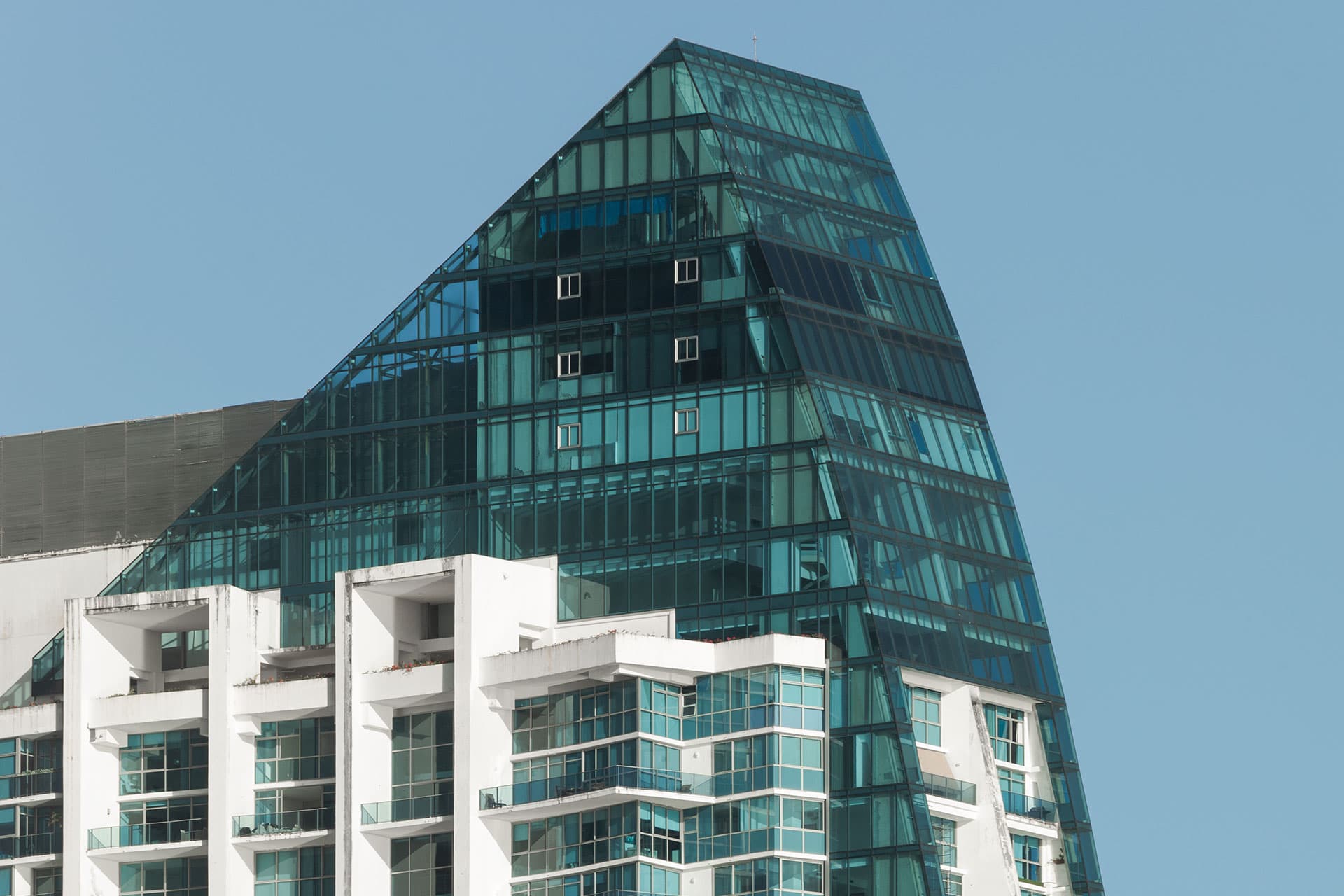 Glass crown of Grand Tower above its white balconies