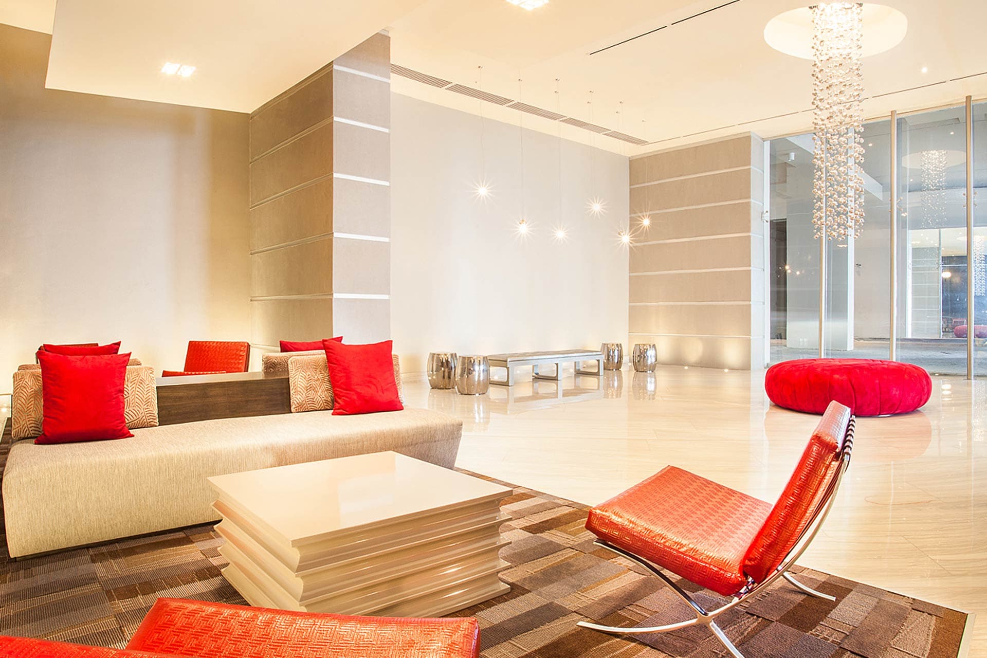 Lobby lounge with red accent furniture and marble floors at Grand Tower