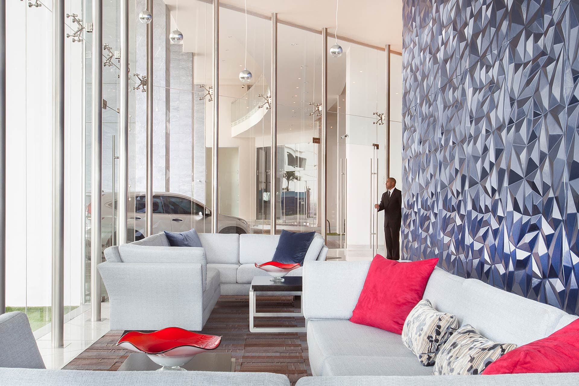 Residents' lounge with glass partitions and faceted feature wall at Grand Tower