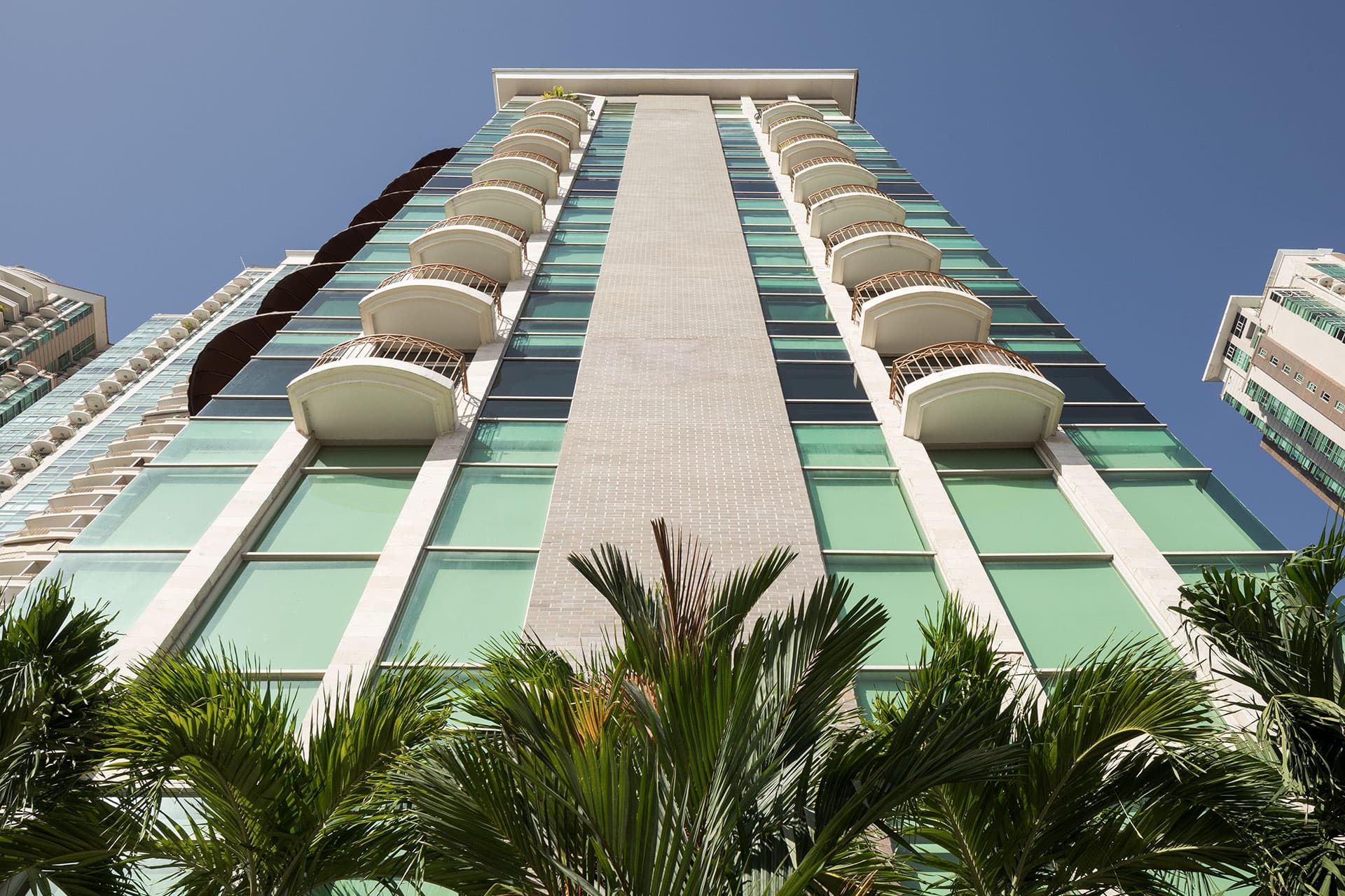 Upward view of a Pacific Point tower rising above palm trees