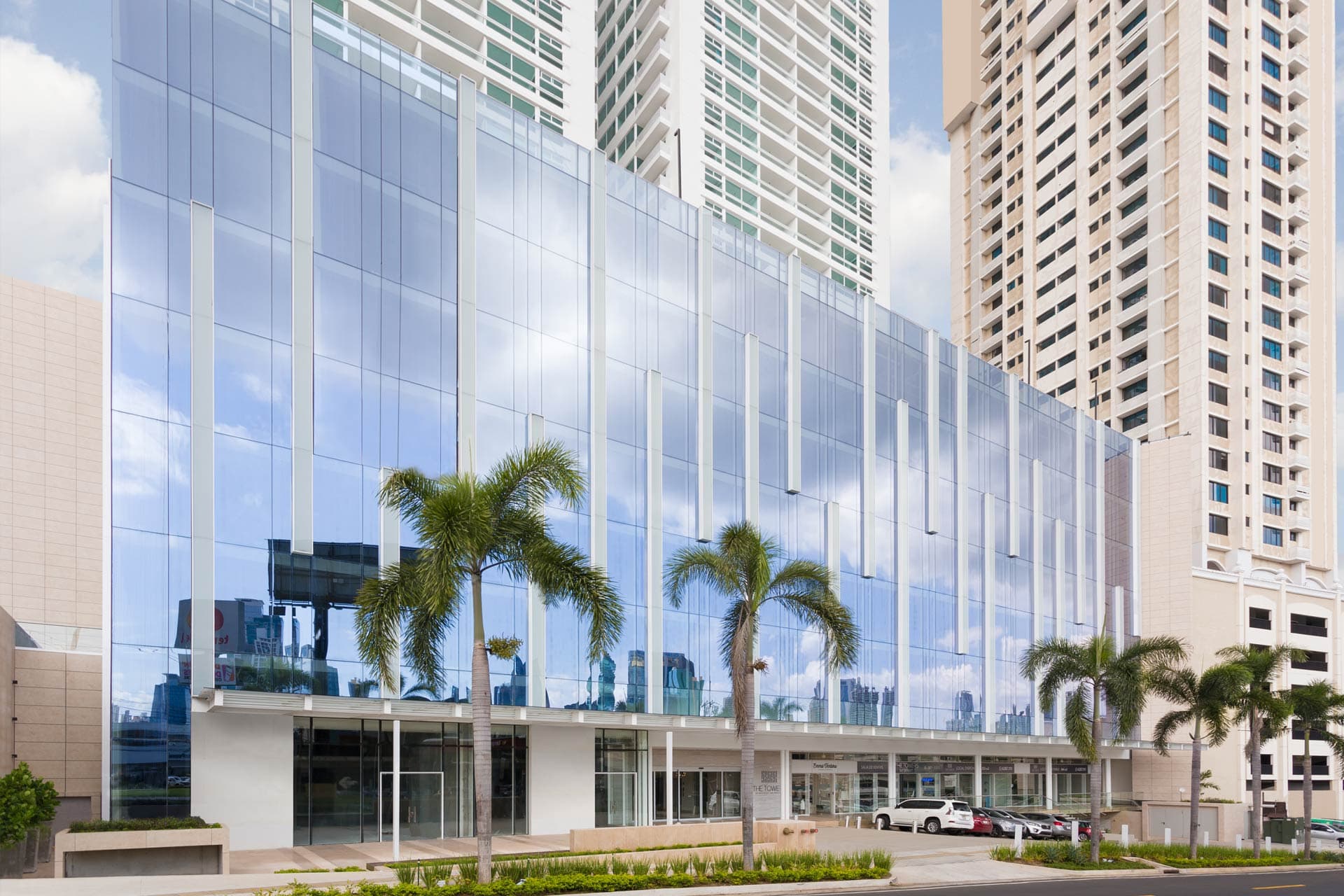 Glass facade of The Towers Business Plaza with palm trees on Calle 50, San Francisco