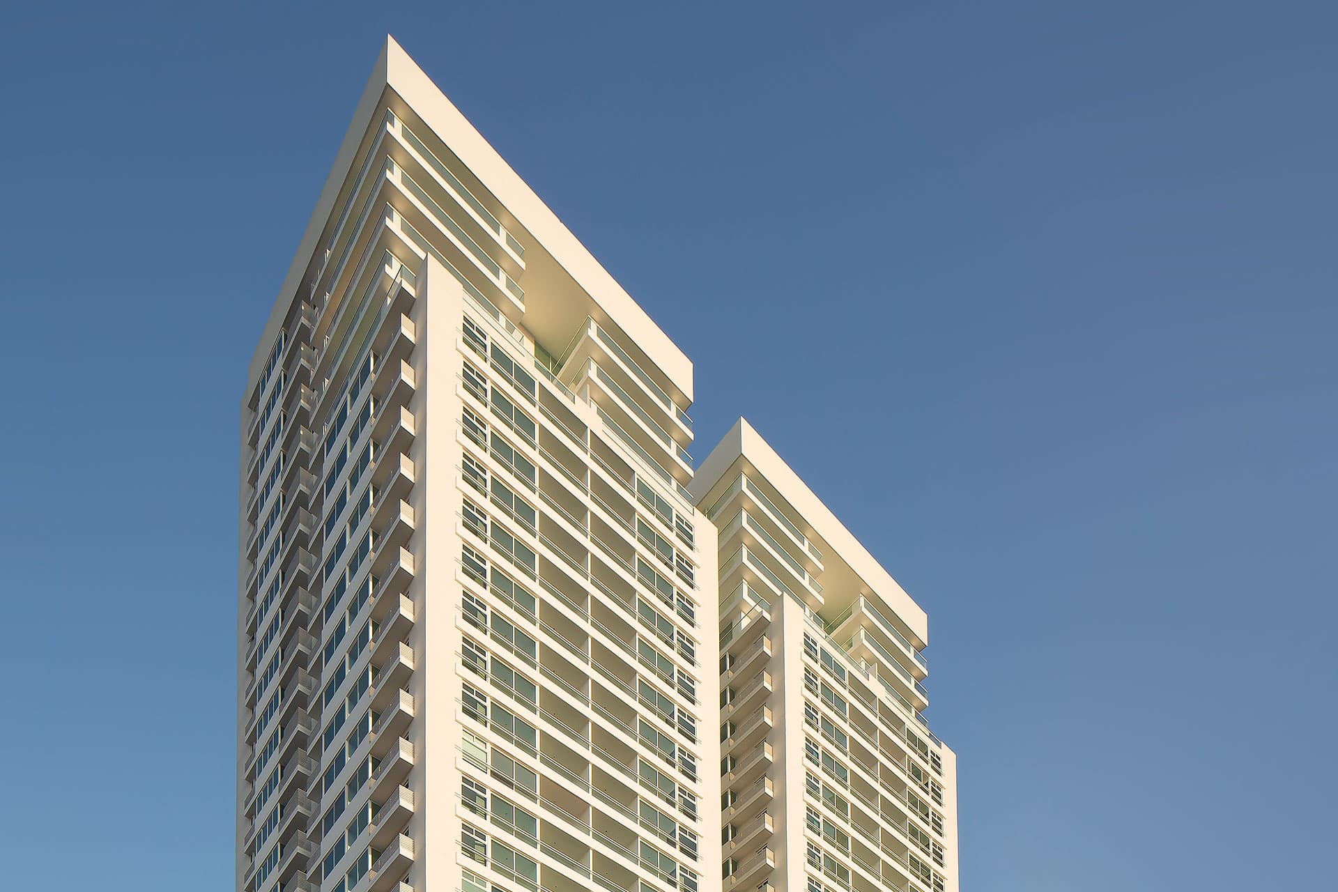 Stepped terraces crowning both towers of The Towers Residences, seen from below