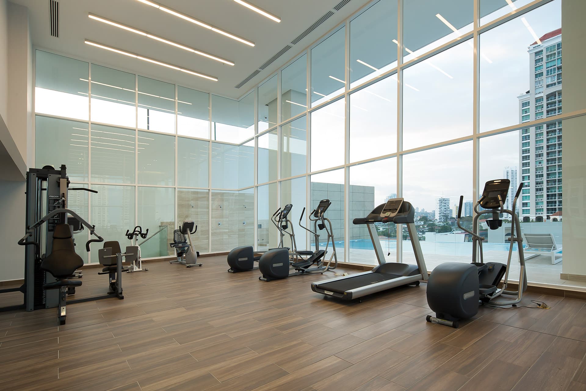 Fitness center with double-height windows at The Towers Residences