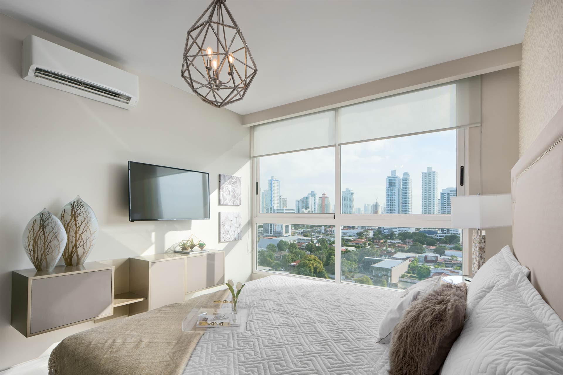 Bedroom with pendant lamp and skyline view in a The Towers Residences apartment