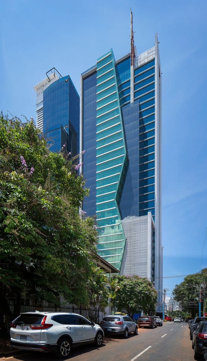 Fortune Plaza glass office tower rising above a tree-lined street in Obarrio