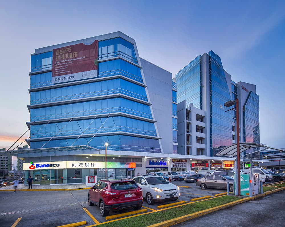 Blue glass office tower of Condado Business Center above its ground-floor shops