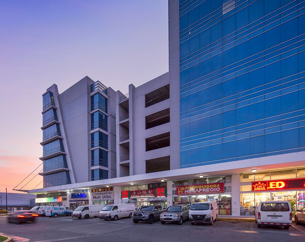 Condado Business Center office towers and retail strip with parking at sunset