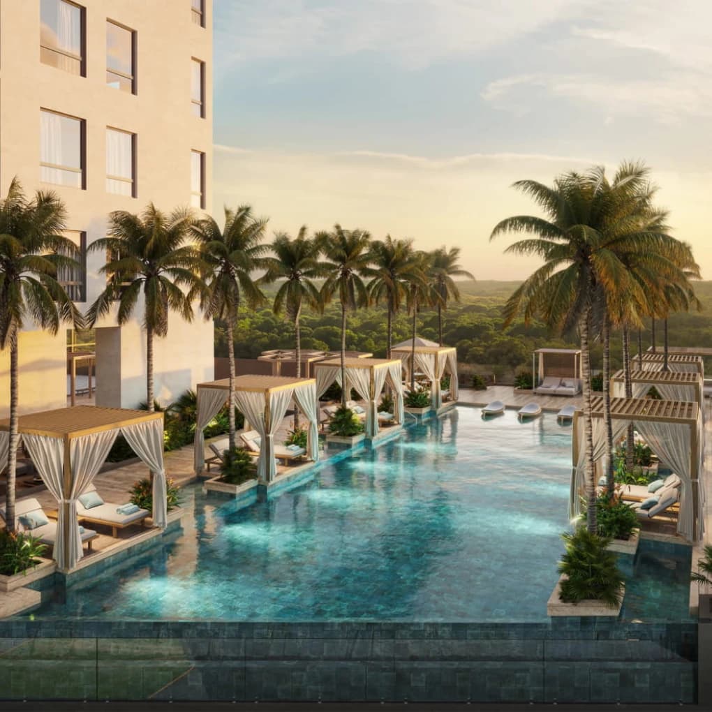 Pool deck with cabanas and palms at sunset at Corotú