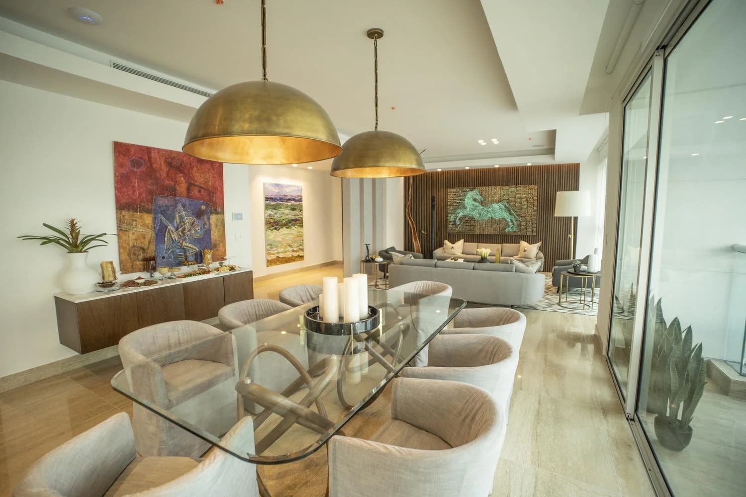 Dining room with brass pendant lamps and glass table at Solana