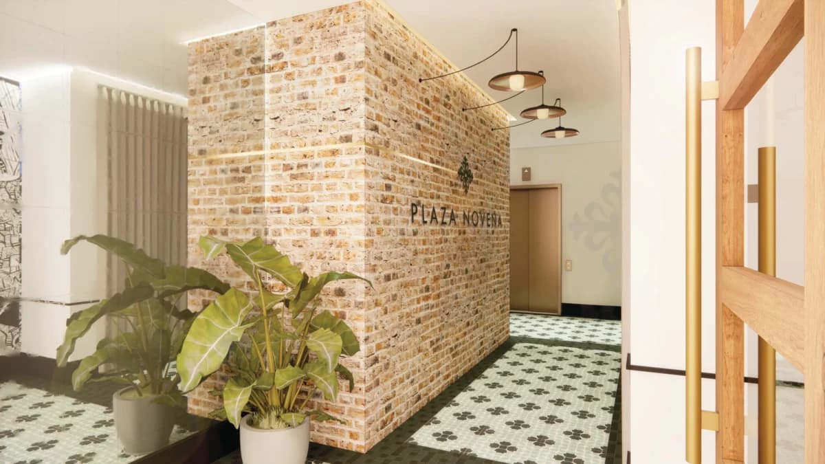 Plaza Novena lobby with exposed brick wall and patterned tile floor
