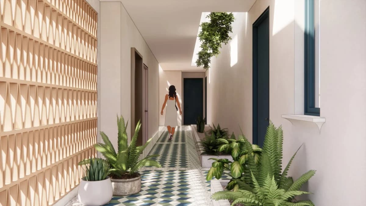 Plant-lined open-air corridor with patterned tiles at Plaza Novena