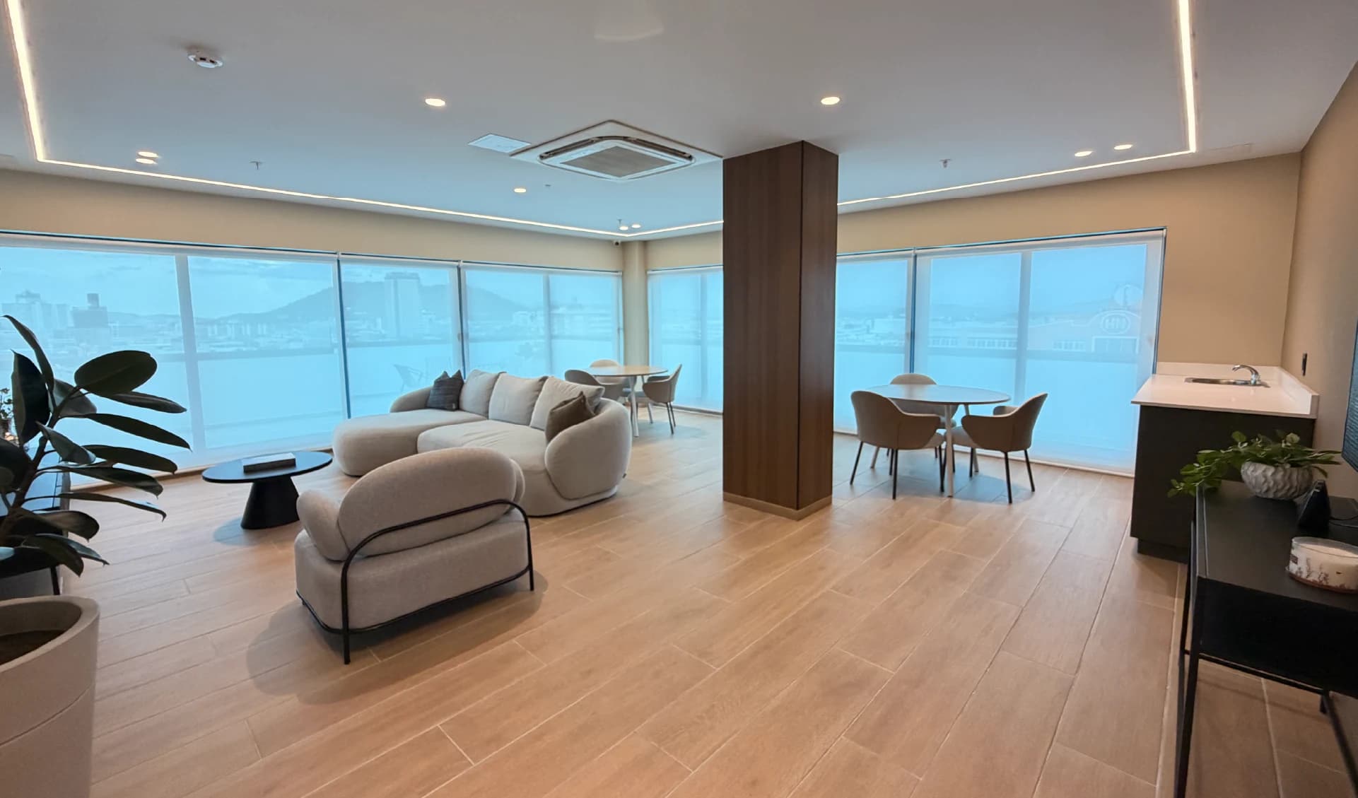 Co-living lounge with bay-view windows at Alexa Bella Vista