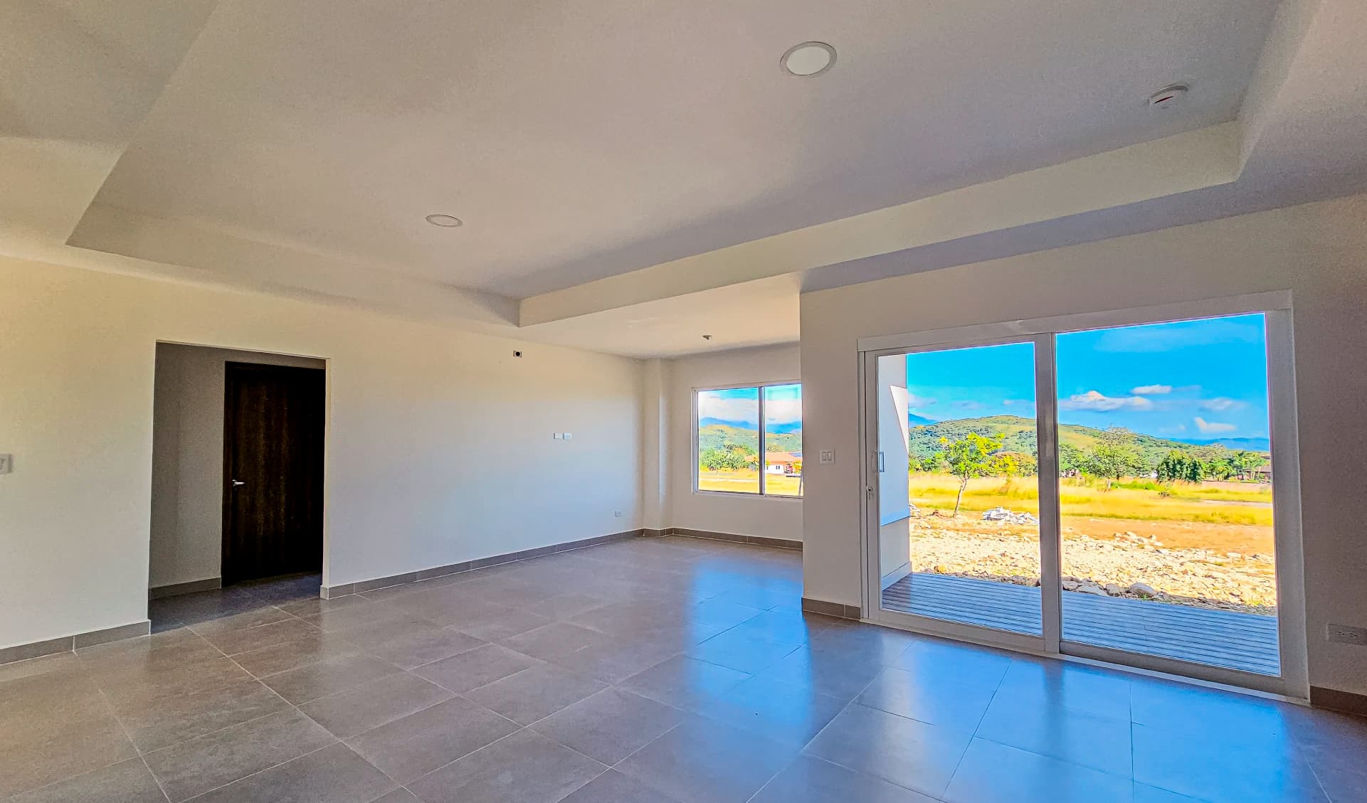 Living room with sliding glass doors and mountain view in a Boquete Canyon Village house