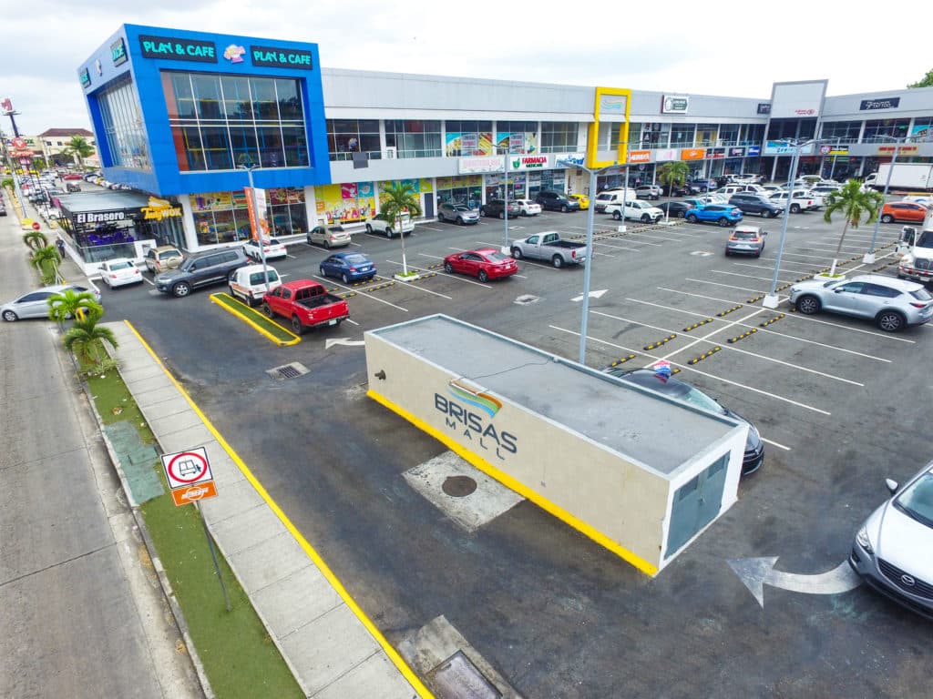 Brisas Mall's two-level retail front, parking and sign kiosk on the main avenue of Brisas del Golf