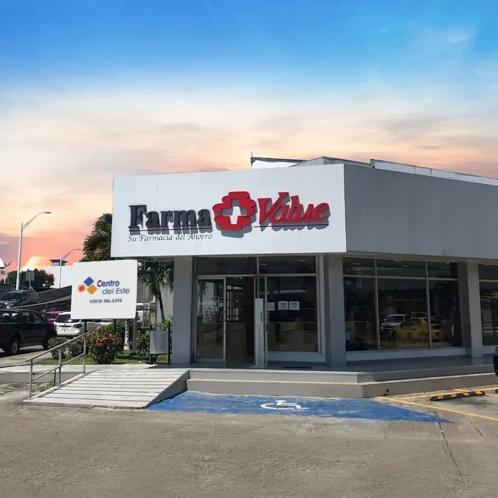 Corner pharmacy storefront at the Centro del Este plaza at sunset