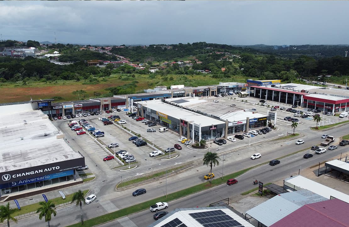 Aerial view of Uniplaza Costa Verde beside the highway with its parking and hills behind