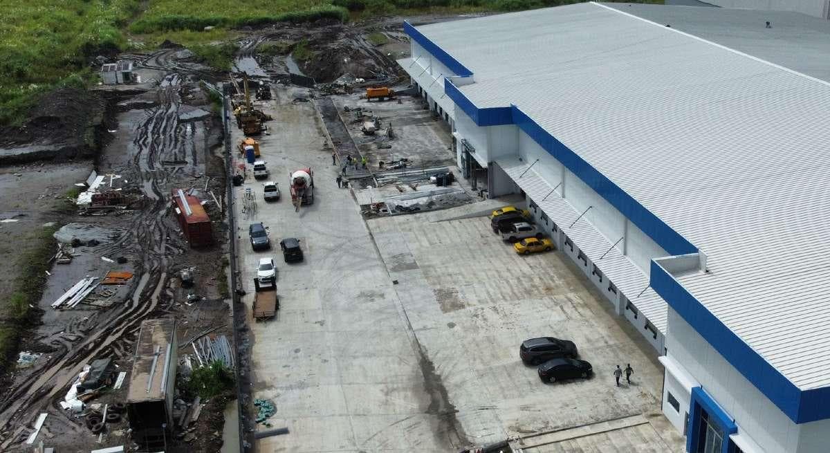 Aerial view of the yard and warehouse at Parque Logístico Cocosolito with the Colón Free Zone behind