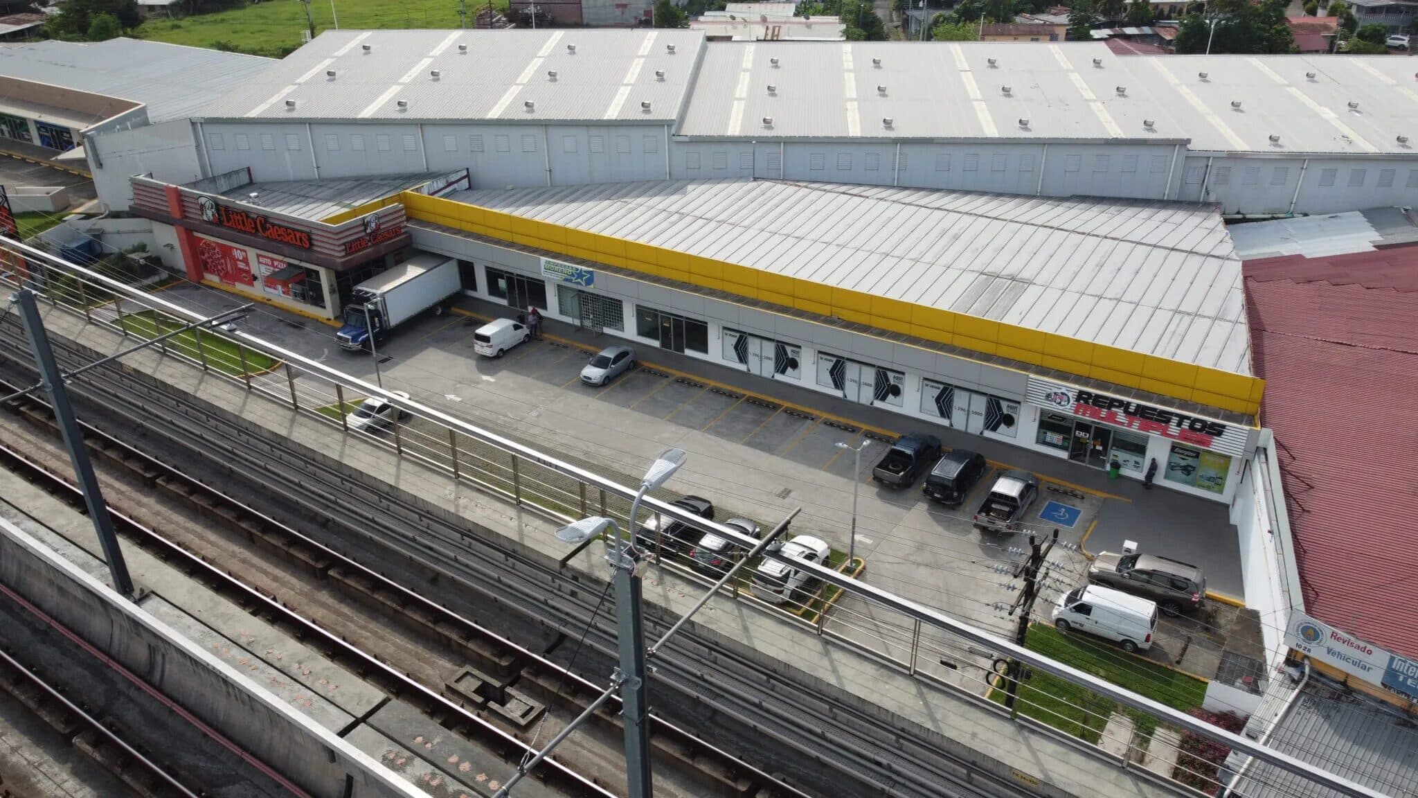 Aerial view of the Silver Plaza commercial building beside the Metro Line 2 viaduct in Las Mañanitas