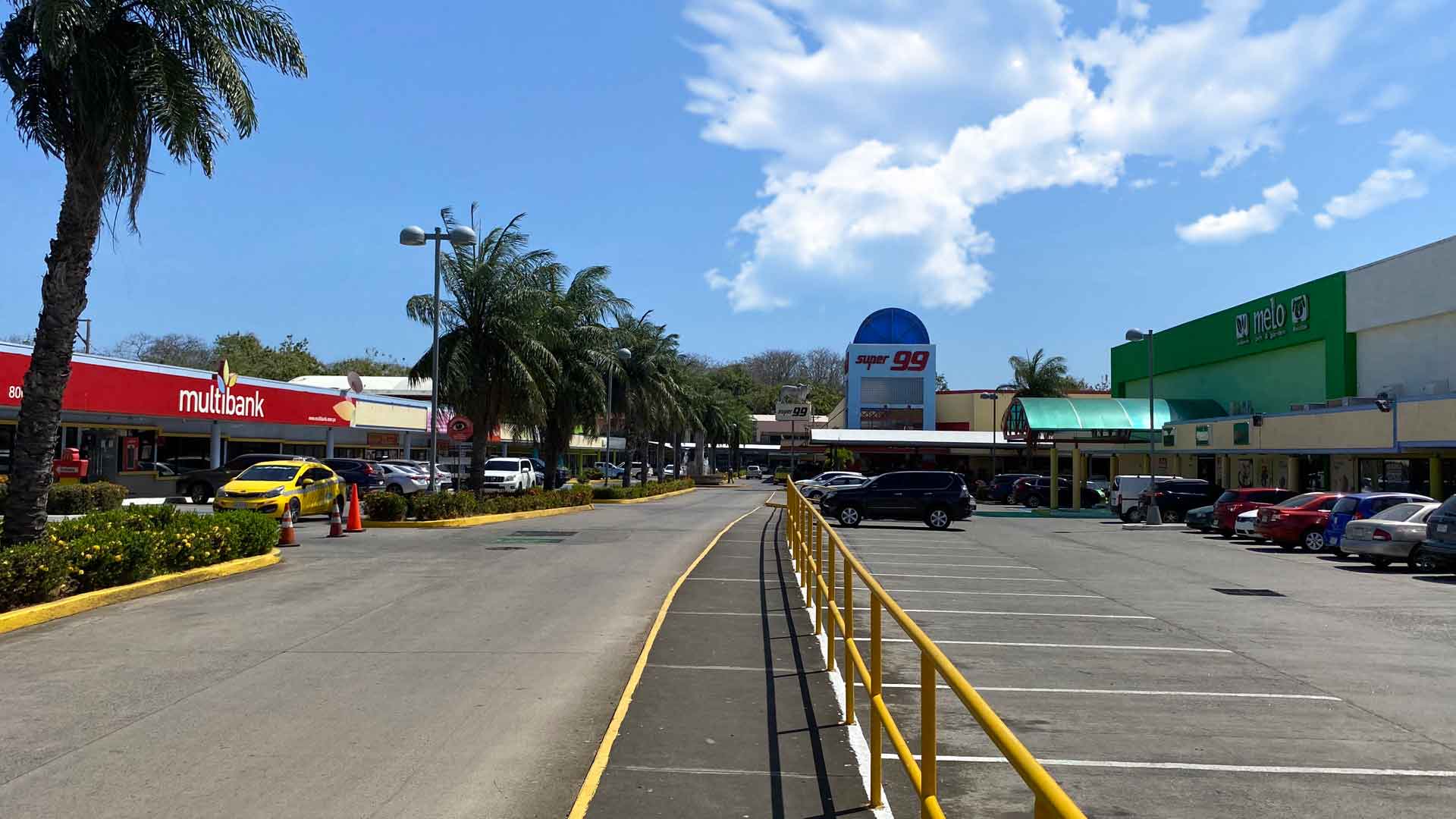 Palm-lined parking lanes between the Plaza Azuero buildings
