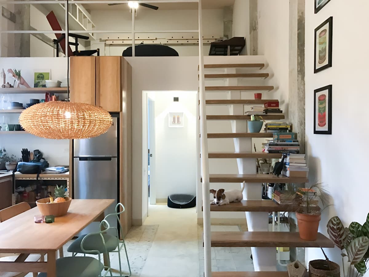 Casa 8-23 apartment with open staircase, dining table and kitchen
