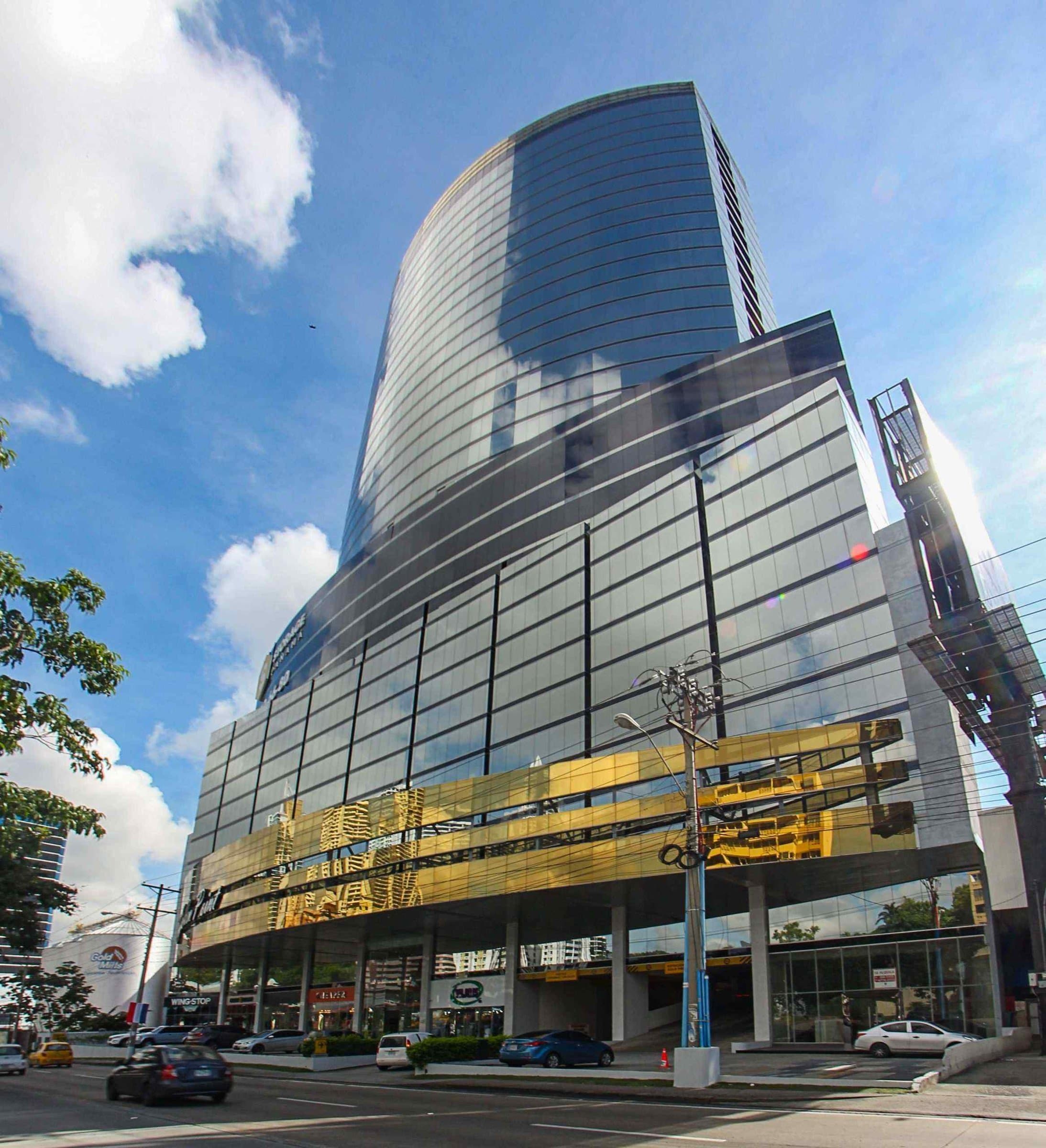 Golden Point Tower office building with its glass cylinder and gold-clad podium on Vía Ricardo J. Alfaro, Panama City