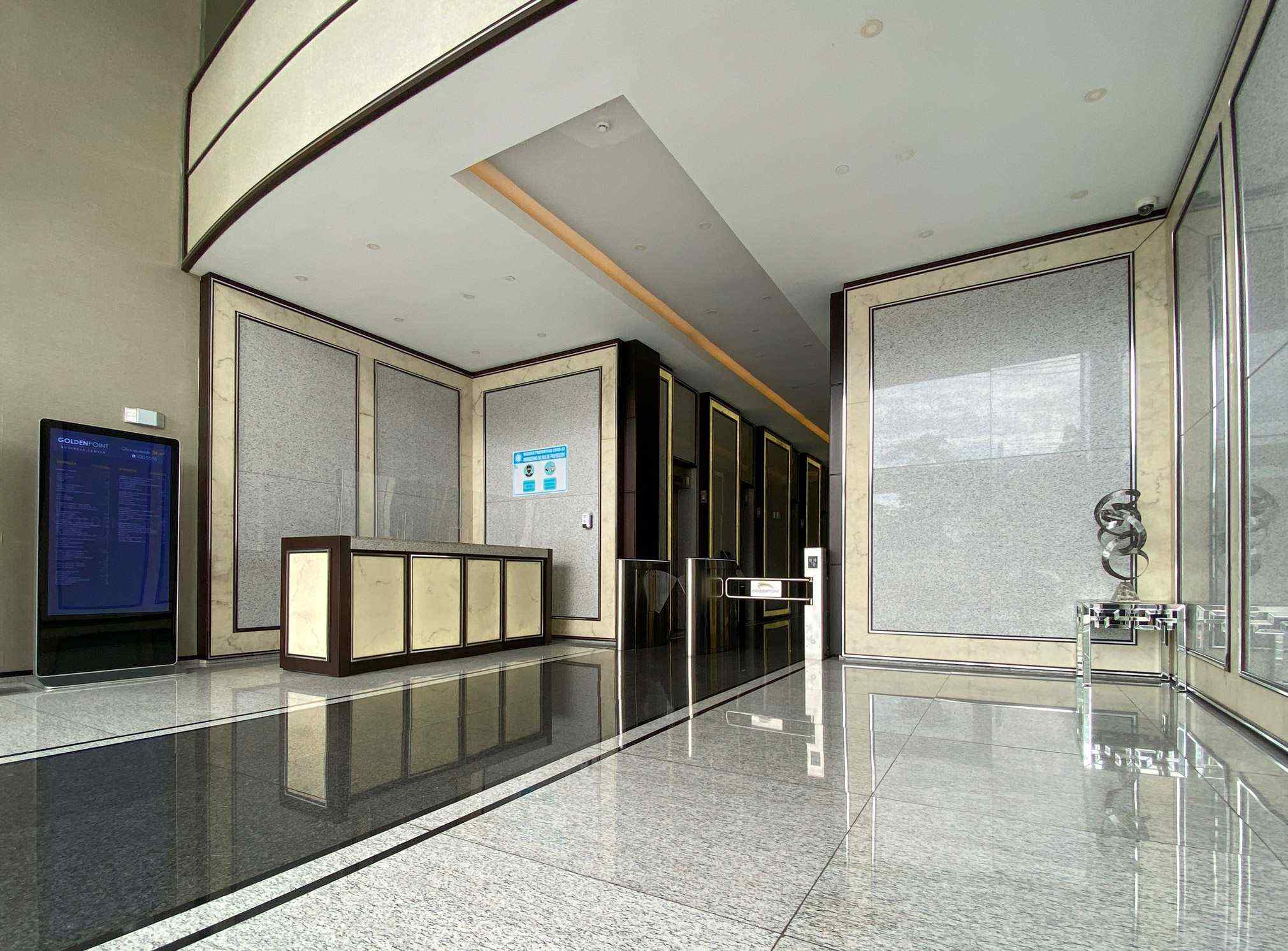 Marble lobby with reception desk and access turnstiles at Golden Point Tower