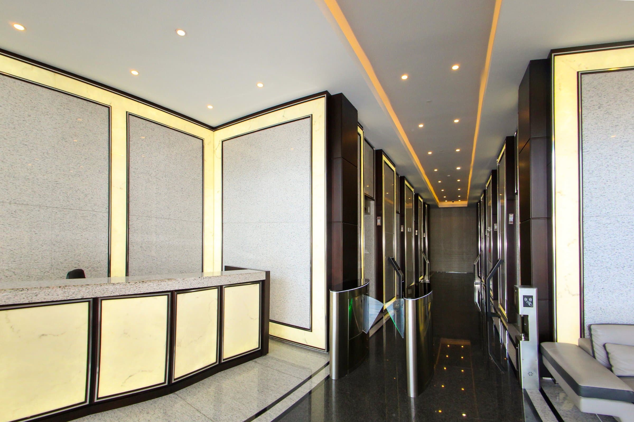 Reception and elevator hall with backlit stone panels at Golden Point Tower