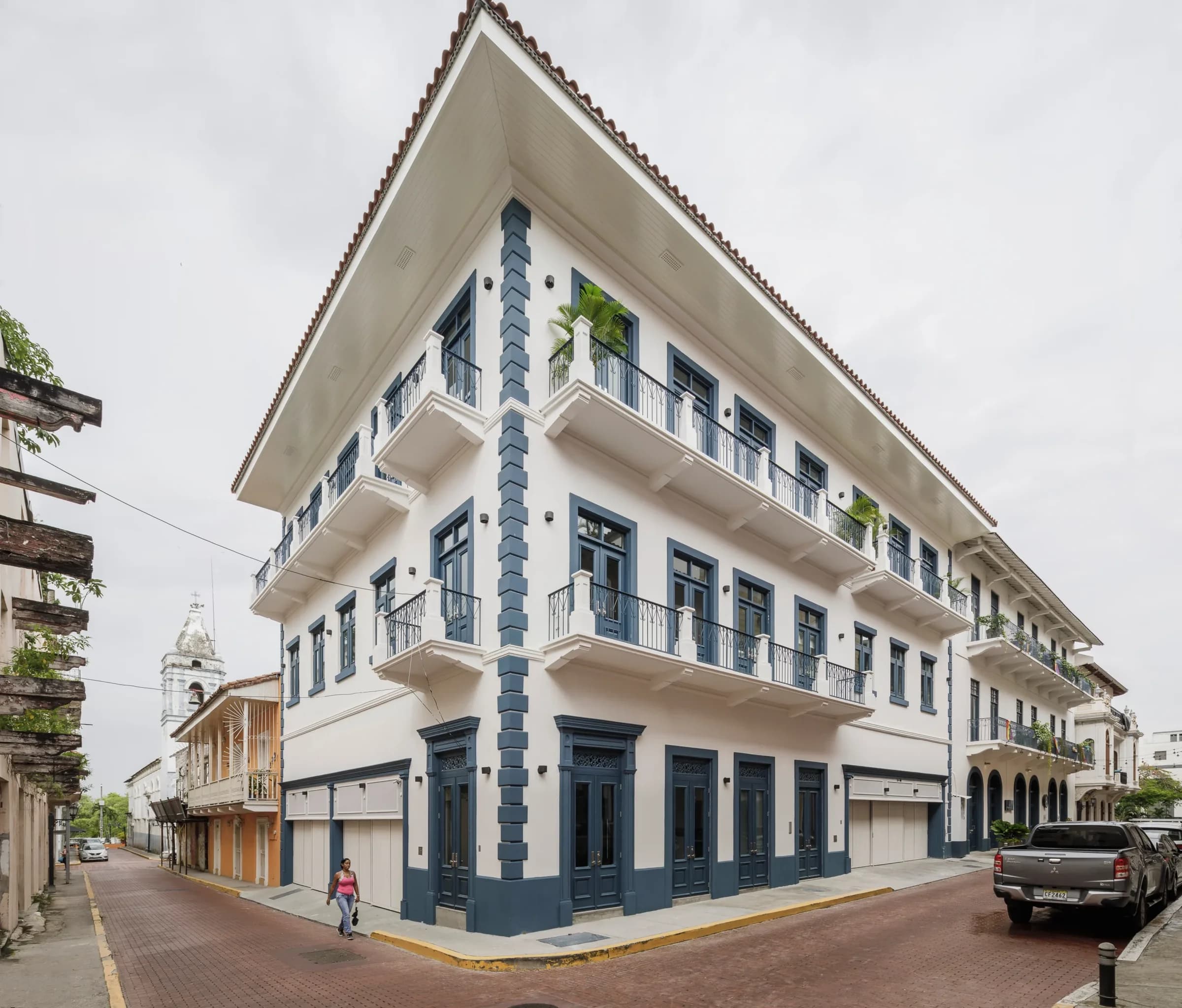 El Colegio II office building, a restored white corner building with blue pilasters on a street in San Felipe, Casco Viejo