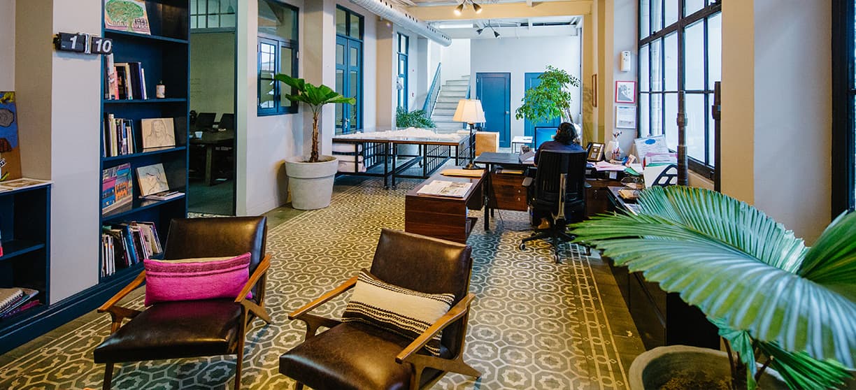 Office lounge with leather armchairs and bookshelves inside El Colegio II, Casco Viejo
