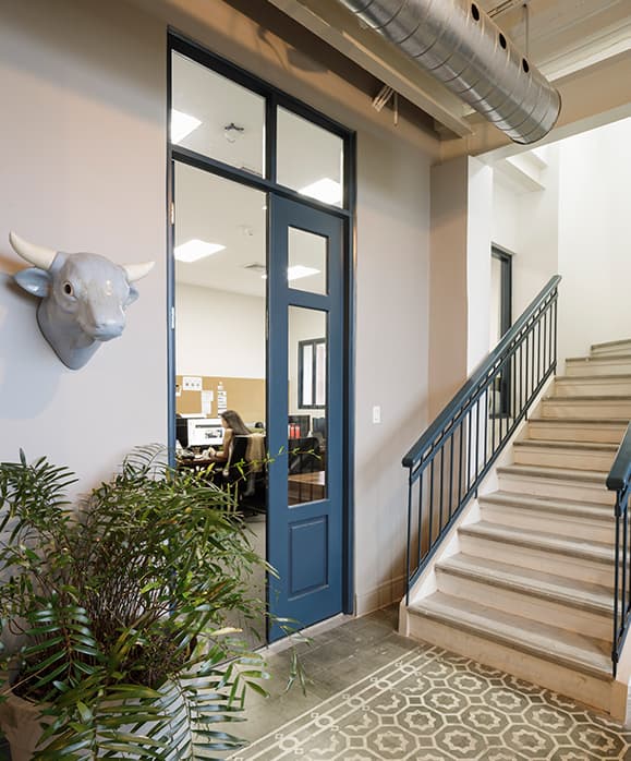 Restored interior staircase with blue-framed doors at El Colegio II, Casco Viejo