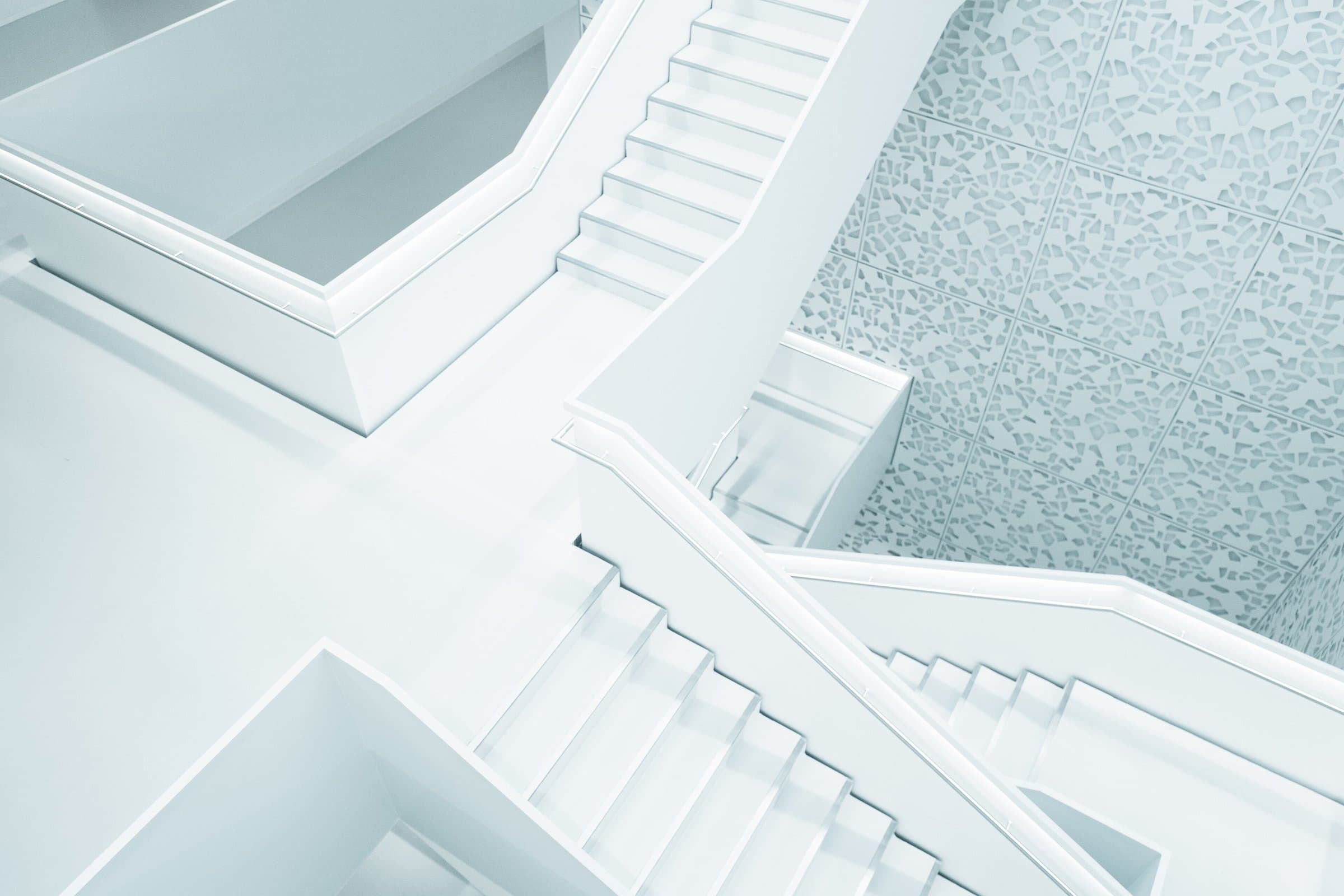 Bright white interior staircase seen from above, linking two levels