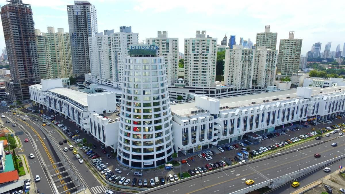 Aerial photograph of Edison Plaza with its cylindrical glass tower and parking beside Via Transistmica, Edison Park