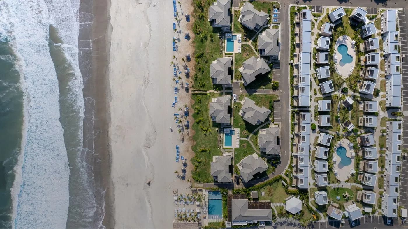 Top-down aerial view of The Tides townhouses, pools and beach at Playa Caracol