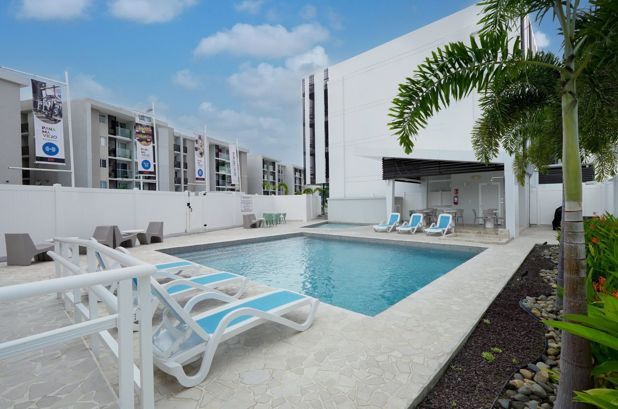 Swimming pool with loungers and palms at Panama Viejo Residences