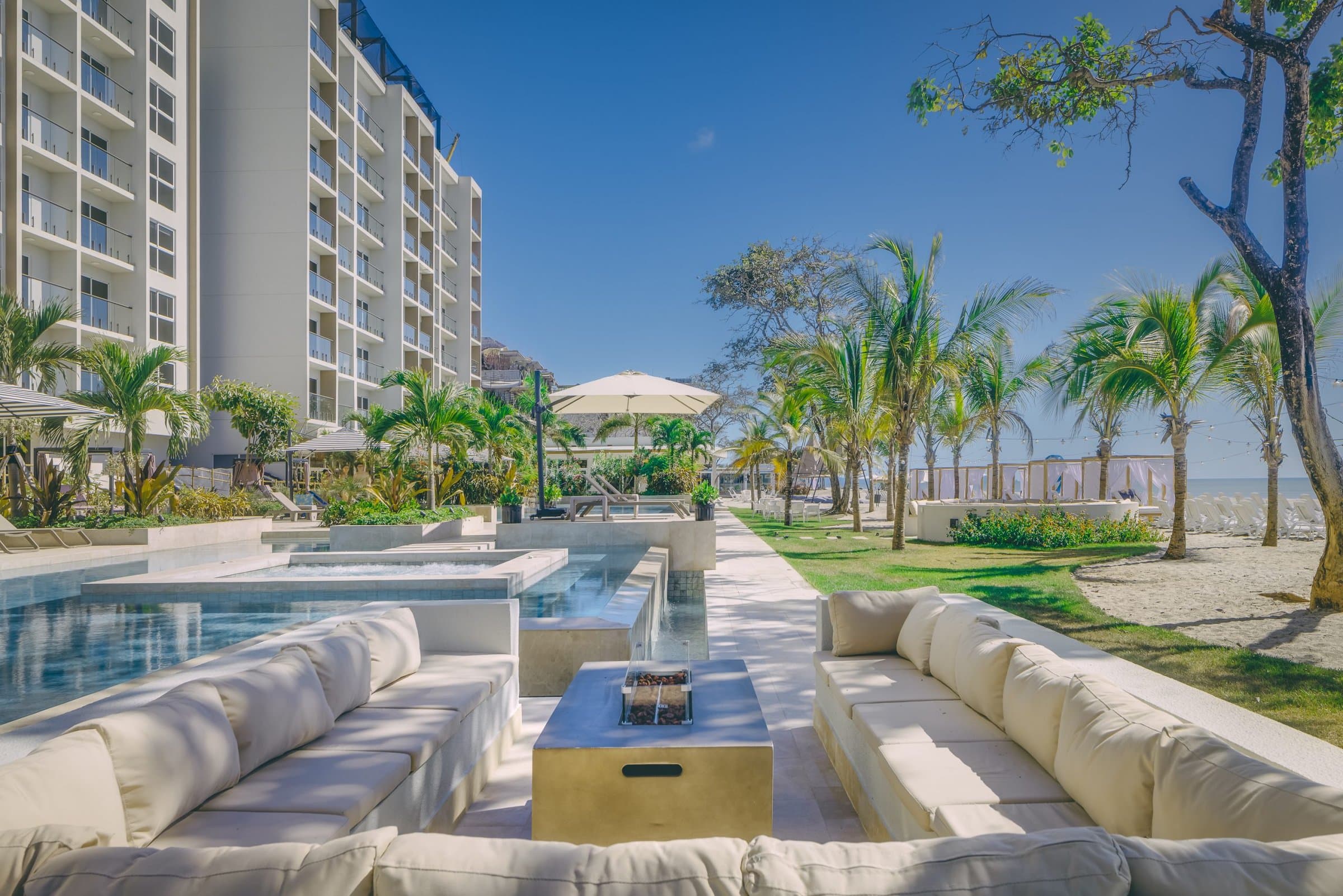 Surfside pool lounge with outdoor sofas and palm trees