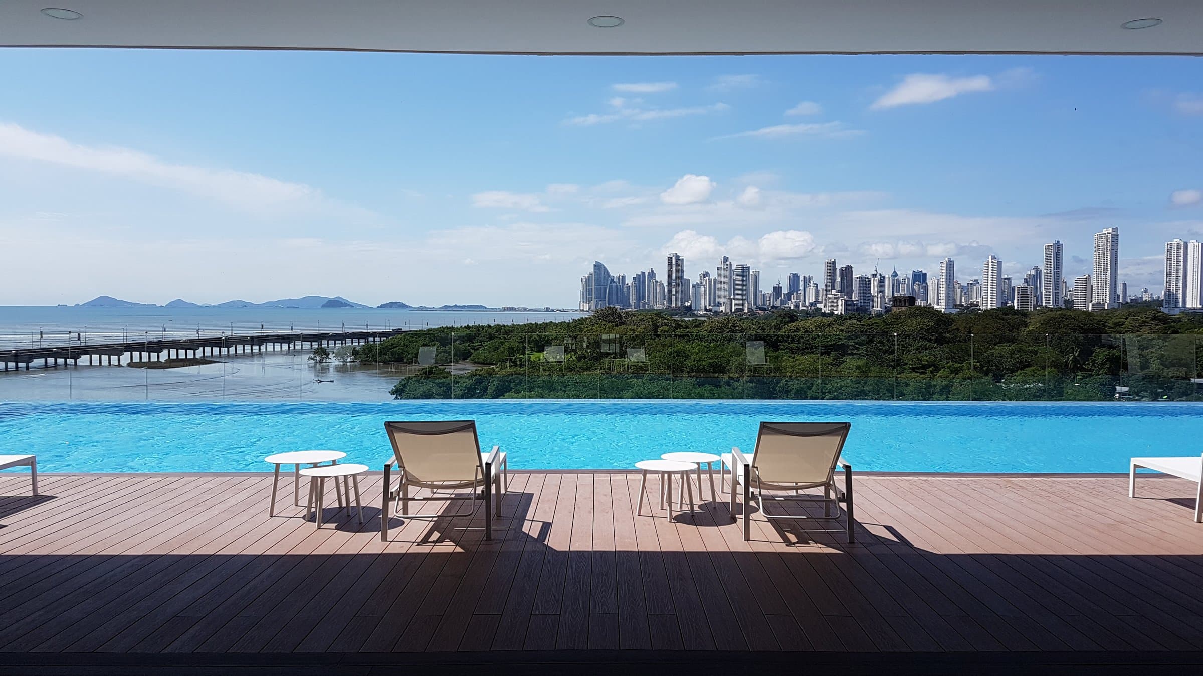 Infinity pool deck at Bali with sun loungers and the Panama City skyline