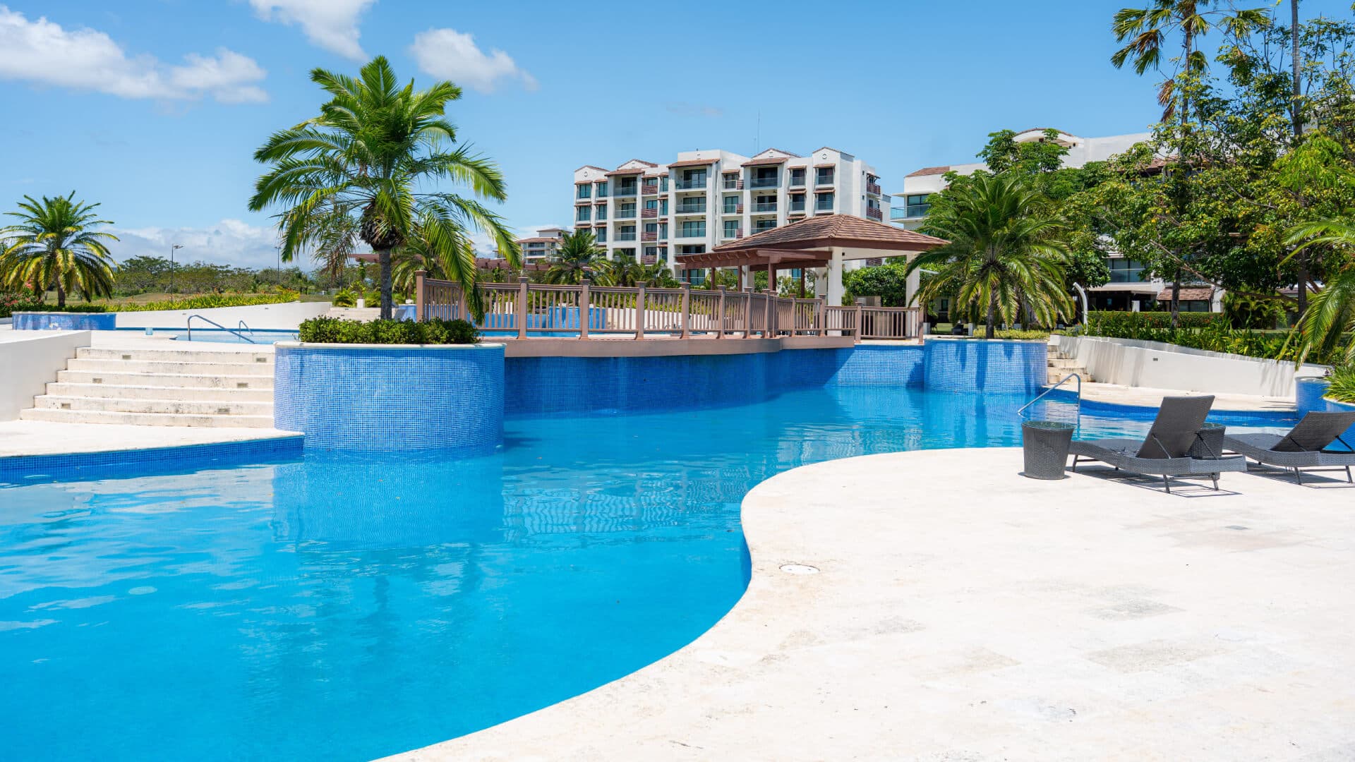 Casamar residential building behind the palm-lined swimming pool in San Carlos, Panama
