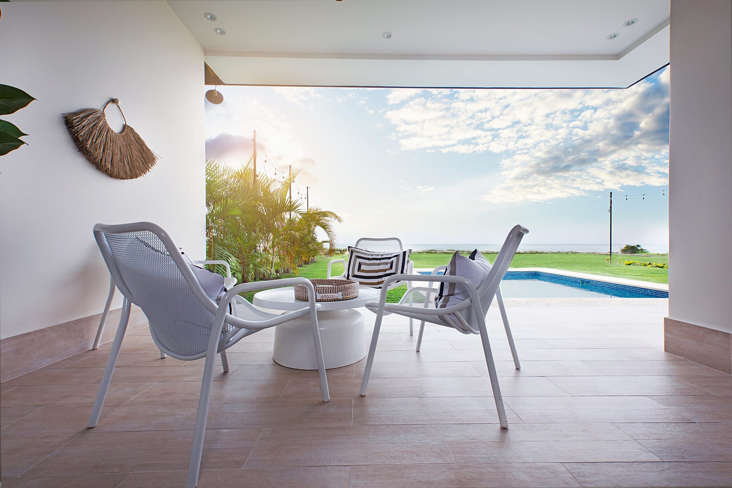 Covered terrace of an Ocean Villas home opening to the pool and lawn